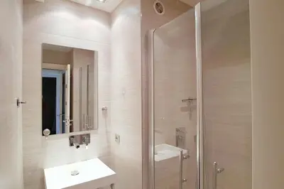 a bathroom with a shower and a sink and a mirror at 4-Room Apartment with Terrace & Sea View 5-Minute Walk to the Beach in Cannes