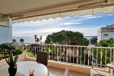 a balcony with a table and a view of the ocean at 4-Room Apartment with Terrace & Sea View 5-Minute Walk to the Beach in Cannes