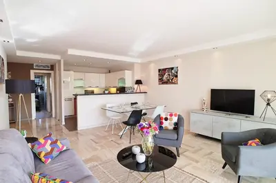 a living room with a couch and chairs and a kitchen at 4-Room Apartment with Terrace & Sea View 5-Minute Walk to the Beach in Cannes