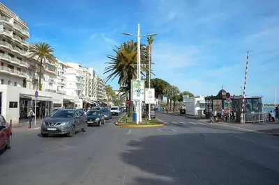 a city street with cars parked on the road at Cannes croisette in Cannes