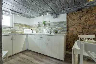 a kitchen with white cabinets and a brick wall at Cannes croisette in Cannes