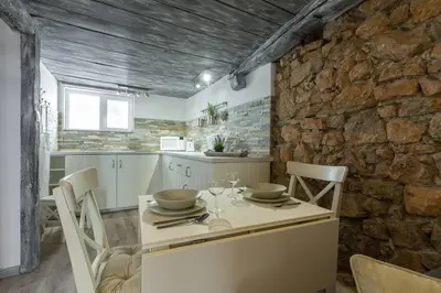 a kitchen with a table and chairs and a stone wall at Cannes croisette in Cannes