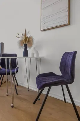 a table with two purple chairs and a vase with a plant at Magnifique appartement - 15 minutes a pieds PALAIS in Cannes