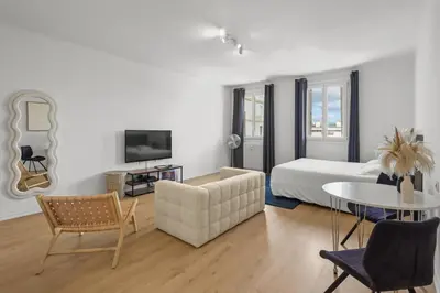 a living room with a bed and a table and chairs at Magnifique appartement - 15 minutes a pieds PALAIS in Cannes