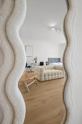 a mirror in a living room with a couch at Magnifique appartement - 15 minutes a pieds PALAIS in Cannes