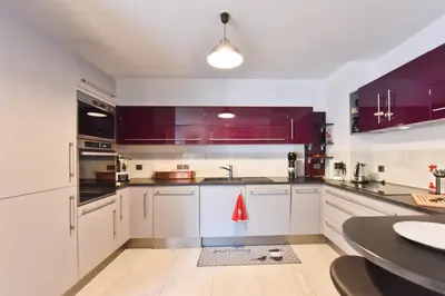 a kitchen with purple cabinets and a table at 2-Br with Terrace and Pool in the Heart of Palm Beach in Cannes