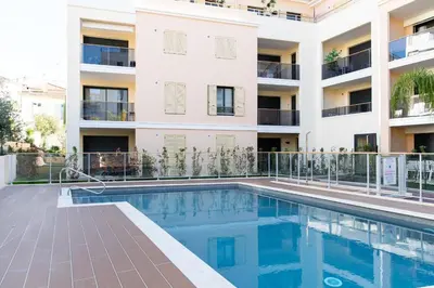 an apartment with a swimming pool in front of a building at 2-Br with Terrace and Pool in the Heart of Palm Beach in Cannes