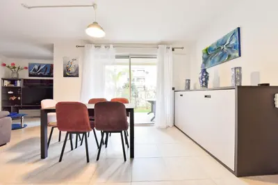 a kitchen and dining room with a table and chairs at 2-Br with Terrace and Pool in the Heart of Palm Beach in Cannes