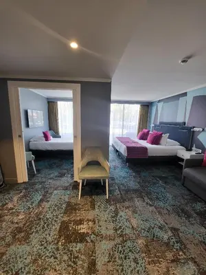 a hotel room with two beds and a couch at Juliana Hotel Cannes in Cannes