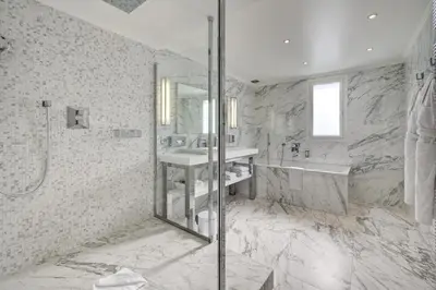 a bathroom with a shower and a sink and a mirror at Juliana Hotel Cannes in Cannes
