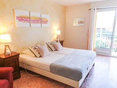 a bedroom with a bed with two lamps and a window at Apartment Reine Astrid-3 by Interhome in Cannes