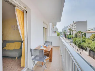 a balcony with a table and chairs and a bed at Apartment Reine Astrid-3 by Interhome in Cannes
