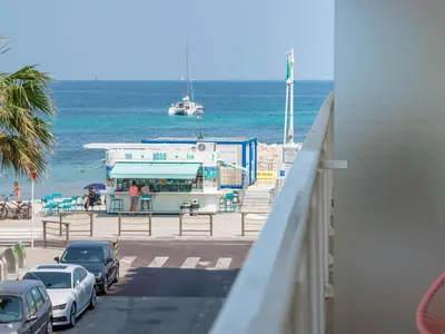a view of the ocean with cars parked on the beach at Apartment Reine Astrid-3 by Interhome in Cannes
