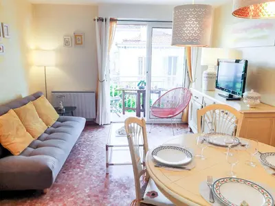 a living room with a table and a couch at Apartment Reine Astrid-3 by Interhome in Cannes