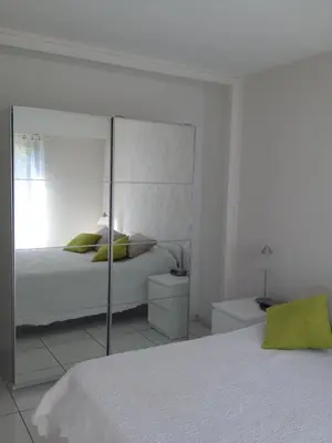 a bedroom with a bed with a mirrored wall at Appartement vacances cannes in Cannes