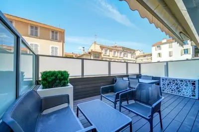 a balcony with chairs and tables on a building at Appartements Croisette Grand Hôtel in Cannes