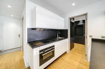 a kitchen with white cabinets and a counter top at Appartements Croisette Grand Hôtel in Cannes