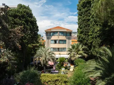 a building with palm trees in front of it at Cézanne Hôtel in Cannes