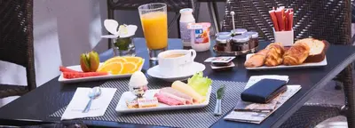 a table with plates of food and drinks on it at GOLDEN TULIP CANNES HOTEL de PARIS in Cannes