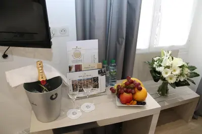 a table with fruit and a vase of flowers at GOLDEN TULIP CANNES HOTEL de PARIS in Cannes