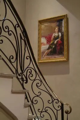 a painting of a woman on the wall next to a staircase at Hôtel Château de la Tour Cannes in Cannes