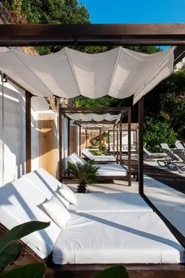 a group of white beds under an umbrella at Hôtel Château de la Tour Cannes in Cannes