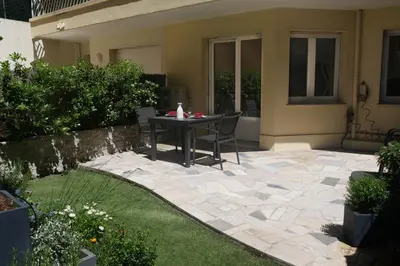 a patio with a table and chairs in a yard at Studio Terrasse in Cannes