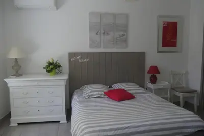 a bedroom with a bed with a red pillow and a dresser at Studio Terrasse in Cannes