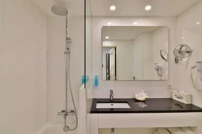a bathroom with a sink and a shower and a mirror at Best Western Plus Cannes Riviera & SPA in Cannes