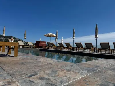 a swimming pool with lounge chairs and an umbrella at Best Western Plus Cannes Riviera & SPA in Cannes
