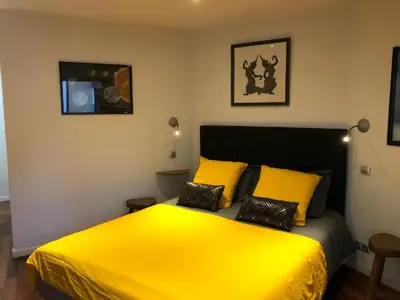 a bedroom with a yellow bed with two pillows at appartement vue mer in Cannes