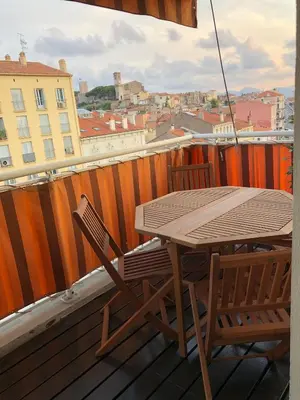 a wooden table and two chairs on a balcony at appartement vue mer in Cannes