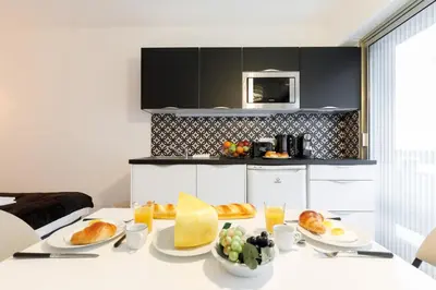 a table with plates of food on it in a kitchen at Le Minerve YourHostHelper in Cannes