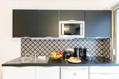 a kitchen with a counter with a bowl of fruit on it at Le Minerve YourHostHelper in Cannes