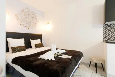 a hotel room with a bed with a statue on it at Le Minerve YourHostHelper in Cannes