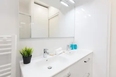a white bathroom with a sink and a mirror at L'Albion YourHostHelper in Cannes