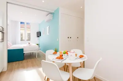 a white dining room with a table and chairs at L'Albion YourHostHelper in Cannes