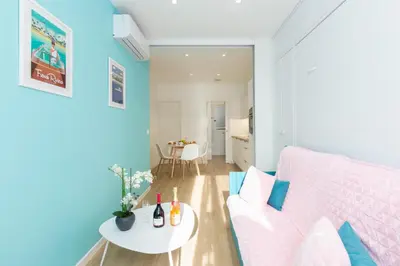 a living room with a pink couch and a table at L'Albion YourHostHelper in Cannes