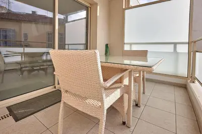 a dining room table with a chair and a window at Appartement Résidence Montaigne in Cannes