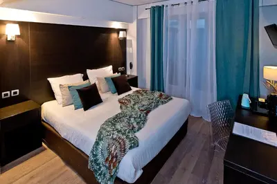 a hotel room with a large bed with white sheets at ATH hôtel Athénée in Cannes