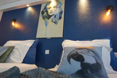 a bedroom with two beds and a picture of a woman at ATH hôtel Athénée in Cannes