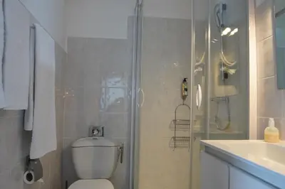 a bathroom with a shower and a toilet and a sink at ATH hôtel Athénée in Cannes