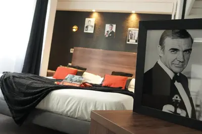 a picture of a man in a suit on a bed at ATH hôtel Athénée in Cannes
