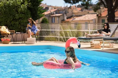 a young girl in a swimming pool with an inflatable at Best Western Hôtel des Orangers Cannes in Cannes