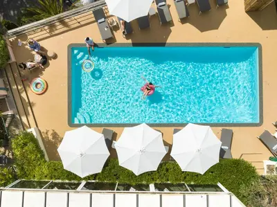 an overhead view of a swimming pool with umbrellas at Best Western Hôtel des Orangers Cannes in Cannes