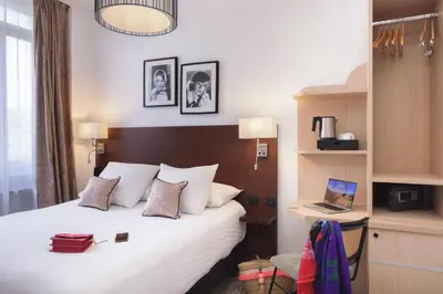 a bedroom with a bed and a laptop on a desk at Best Western Hôtel des Orangers Cannes in Cannes