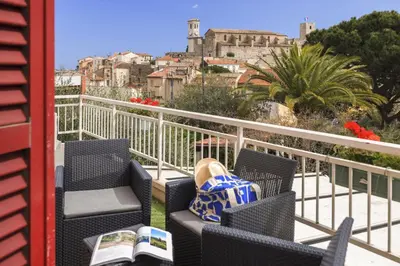 a balcony with chairs and a view of a city at Best Western Hôtel des Orangers Cannes in Cannes