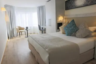 a hotel room with a large white bed with pillows at Eden Hotel & Spa in Cannes
