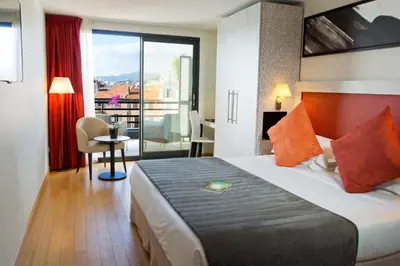 a hotel room with a bed and a balcony at Eden Hotel & Spa in Cannes