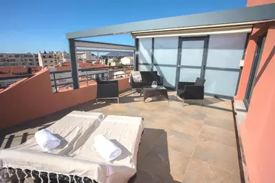 a balcony with two beds and chairs on a roof at Eden Hotel & Spa in Cannes